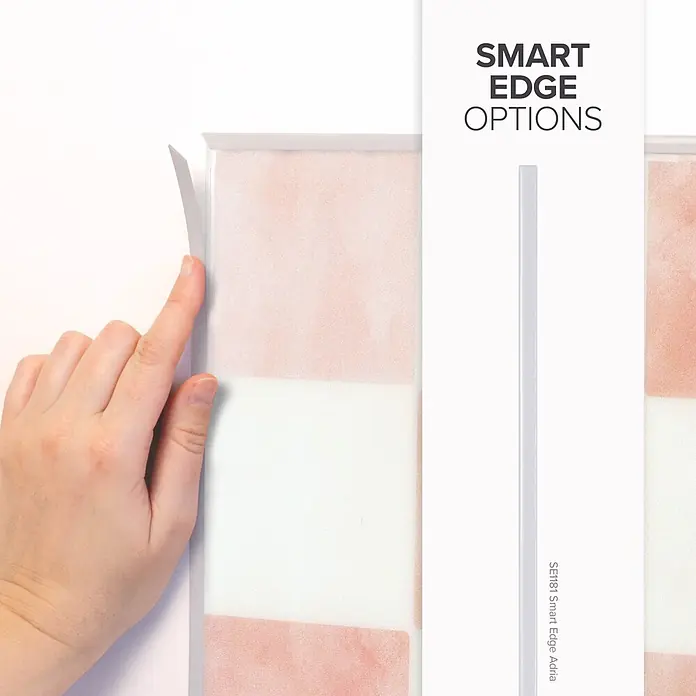 Smart Tiles Selbstklebemosaik Damier - 19,69 x 19,69 cm, Petra, Matt - Hand zieht eine Smart Edge von einer Platte mit rosa-weißem Muster ab. Zeigt Kantenflexibilität und Design.