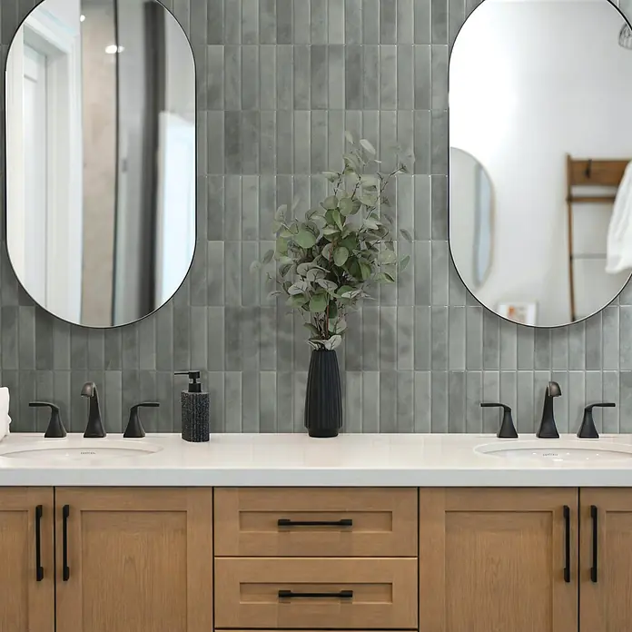 Smart Tiles Selbstklebemosaik Morocco - 29,02 x 22,86 cm, Casa, Glänzend - Moderner Doppelwaschtisch mit hellen Holzschränken, weißer Arbeitsplatte, schwarzen Armaturen und ovalen Spiegeln, mit grauem Fliesenrückwand.