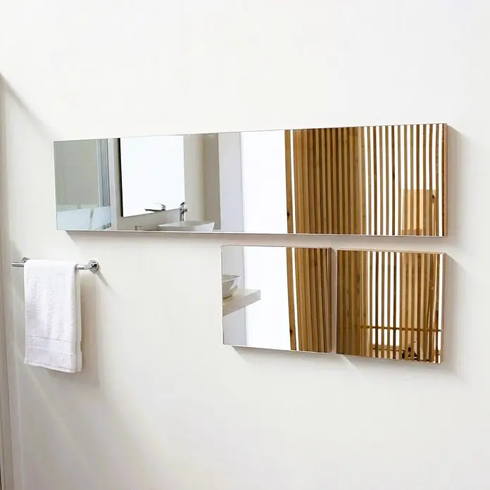 Kiamami Valentina Lichtspiegel - 38 x 300 cm, Farblos - Modernes Wandspiegel-Set mit teilweiser Spiegelfläche und vertikalen Holzlamellen, über einem Handtuchhalter montiert.