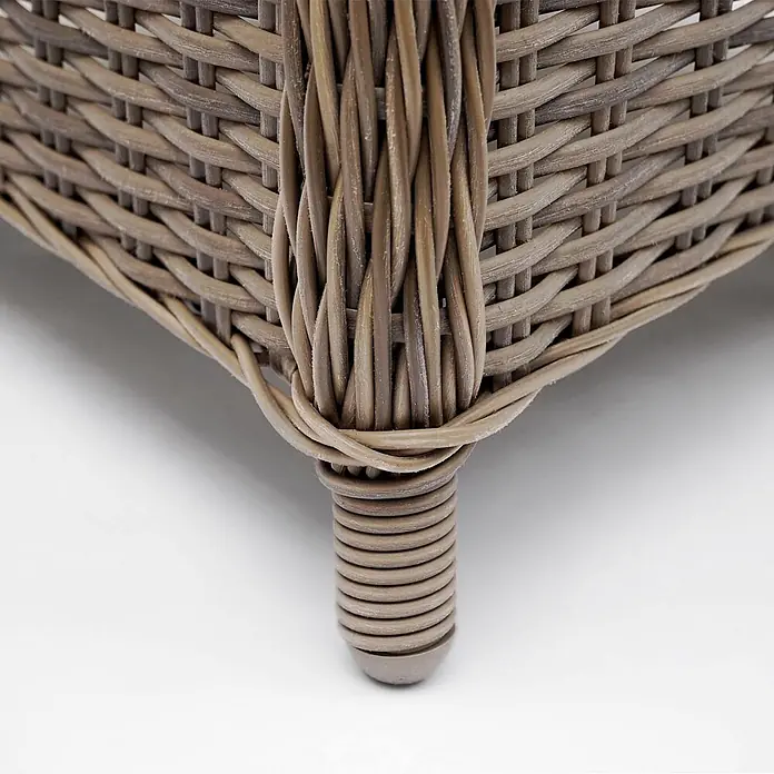 Mendler Gartensessel HWC-E98 - 2 Stk., Polyrattan, Beige, Kissen grau, B x T x H: 63 x 63 x 94 cm - Nahaufnahme eines hellbraunen, geflochtenen Rattan-Möbelbeins mit geripptem Design.