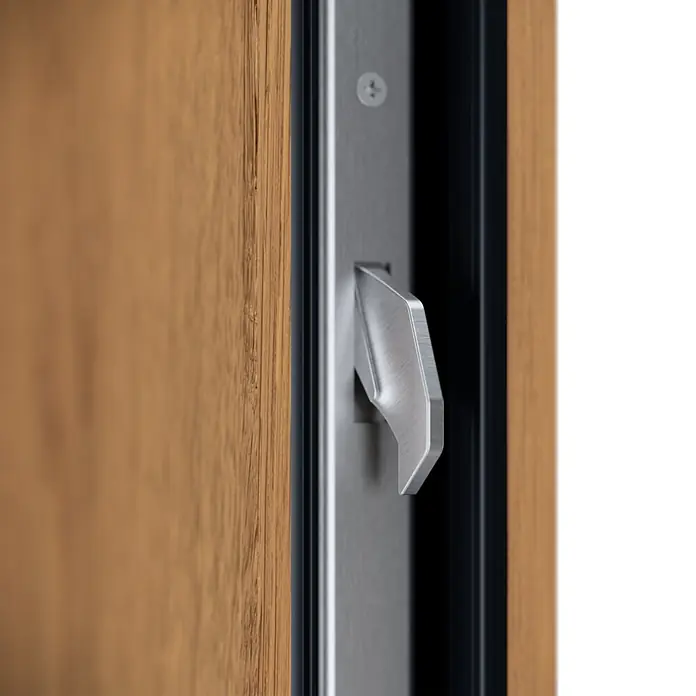 FM Türen Haustür - 110 x 210 cm, DIN Anschlag: Links, Winchester, Mit vertikaler Verglasung + Zierapplikationen - Gebürsteter Metall-Türriegelmechanismus an einem silberfarbenen Türrahmen neben einer Holztür.