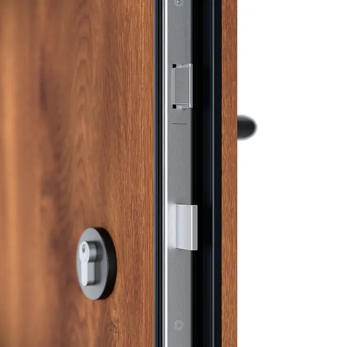 FM Türen Haustür - 110 x 210 cm, DIN Anschlag: Links, Goldene Eiche, Mit vertikaler Verglasung + Zierapplikationen - Nahaufnahme einer teilweise geöffneten braunen Holztür mit silberfarbenem Metallschlossmechanismus und Schließblech.