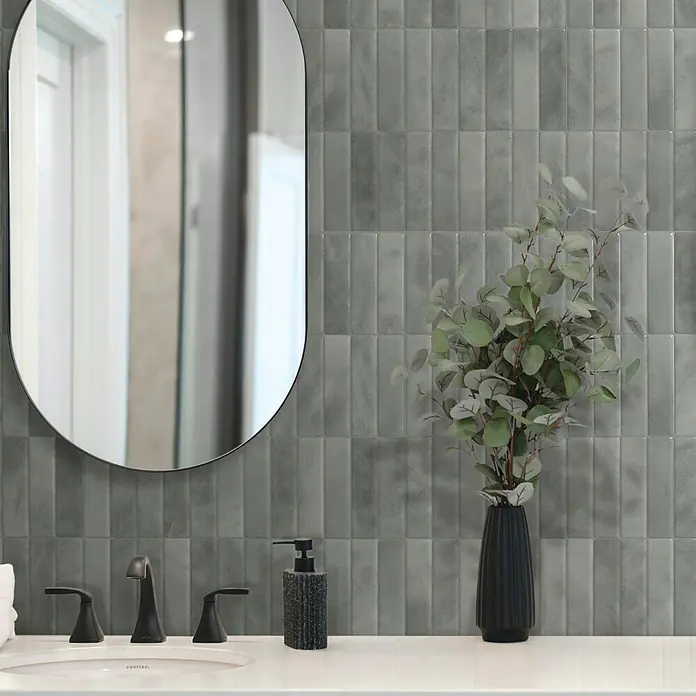 Smart Tiles Selbstklebemosaik Morocco - 29,02 x 22,86 cm, Casa, Glänzend - Moderner Waschtisch mit weißem Waschbecken, mattschwarzer Armatur, schwarzem Spiegel und strukturierten grauen Rechteckfliesen.