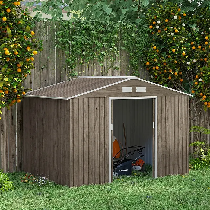 SONNENH Gerätehaus - Außenbreite inkl. Dachüberstand: 277 cm, Außentiefe inkl. Dachüberstand: 195 cm, Stahl, Braun - Braune Gartenhütte in Holzoptik mit Schrägdach und weißer Verkleidung, in einem üppigen Garten mit offener Tür, die einen Rasenmäher im Inneren zeigt.