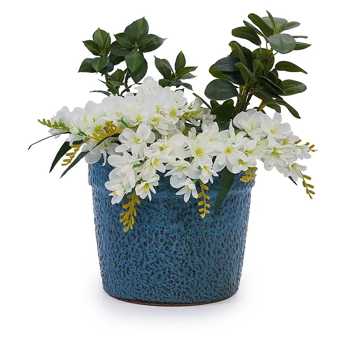 SONNENH Pflanztopf - Keramik, Blau - Ein blauer strukturierter Topf enthält ein Arrangement aus weißen Blüten, grünen Blättern und dezenten gelben Akzenten.