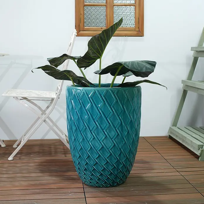 SONNENH Pflanztopf - 1 Stk., Außenmaß (Ø x H): 42 x 54 cm, Keramik, Blau - Großer türkiser Keramikpflanztopf mit geometrischer Textur, enthält eine Pflanze mit dunkelgrünen Blättern auf einer Holzterrasse.
