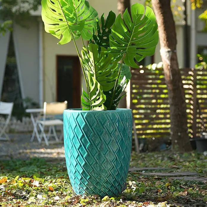 SONNENH Pflanztopf - 1 Stk., Außenmaß (Ø x H): 42 x 54 cm, Keramik, Blau - Türkiser Keramik-Pflanztopf mit Rautenmuster, der eine Monstera-Pflanze in einem Garten enthält.