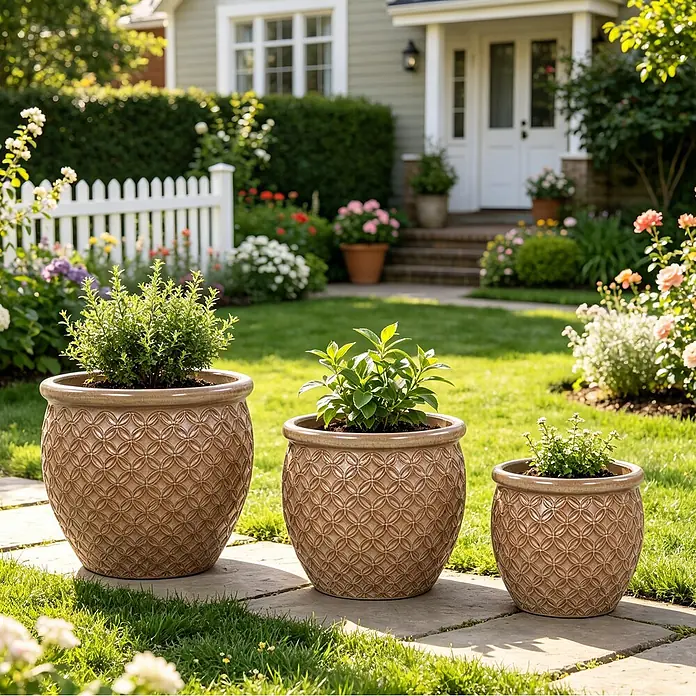 SONNENH Pflanztopf - 3 Stk., Keramik, Beige - Drei braune Pflanzgefäße mit Kreis-Muster, die grüne Pflanzen enthalten, in einem sonnigen Garten.