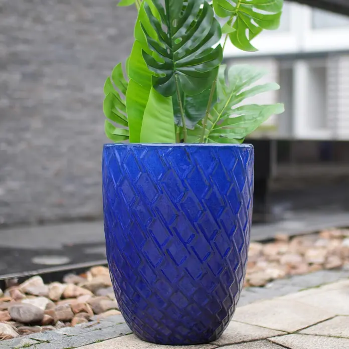 SONNENH Pflanztopf - 1 Stk., Außenmaß (Ø x H): 42 x 54 cm, Keramik, Blau - Lebhaft blauer, gemusterter Pflanzkübel mit üppigen grünen Pflanzen, draußen auf Pflastersteinen.