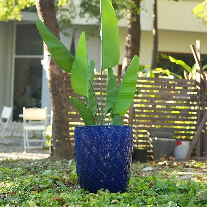 SONNENH Pflanztopf - 1 Stk., Außenmaß (Ø x H): 42 x 54 cm, Keramik, Blau - Blauer Keramik-Pflanztopf mit Rautenmuster, hält eine Pflanze im Freien auf grünem Gras.