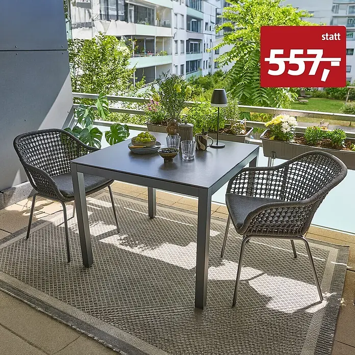 Sunfun Balkonmöbel-Set Maja/Sarah Rope - 3 -tlg., Sintered Stone, Olefin, Grau - Grauer quadratischer Gartentisch und zwei passende graue Geflechtsessel mit Kissen auf einem gemusterten Teppich auf einem Balkon.