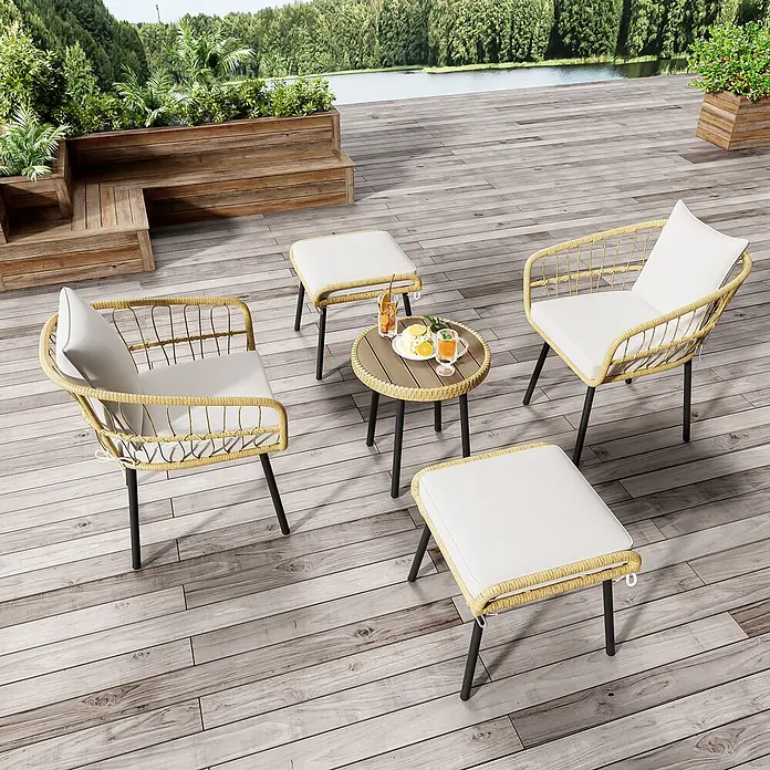 SONNENH Loungemöbel-Set - 5 -tlg., Polyrattan, Fabric, Natur - Gartensitzgruppe mit zwei geflochtenen Stühlen, zwei Hockern und einem runden Tisch mit weißen Kissen, schwarzen Beinen und Getränken auf dem Tisch, auf einer Terrasse.