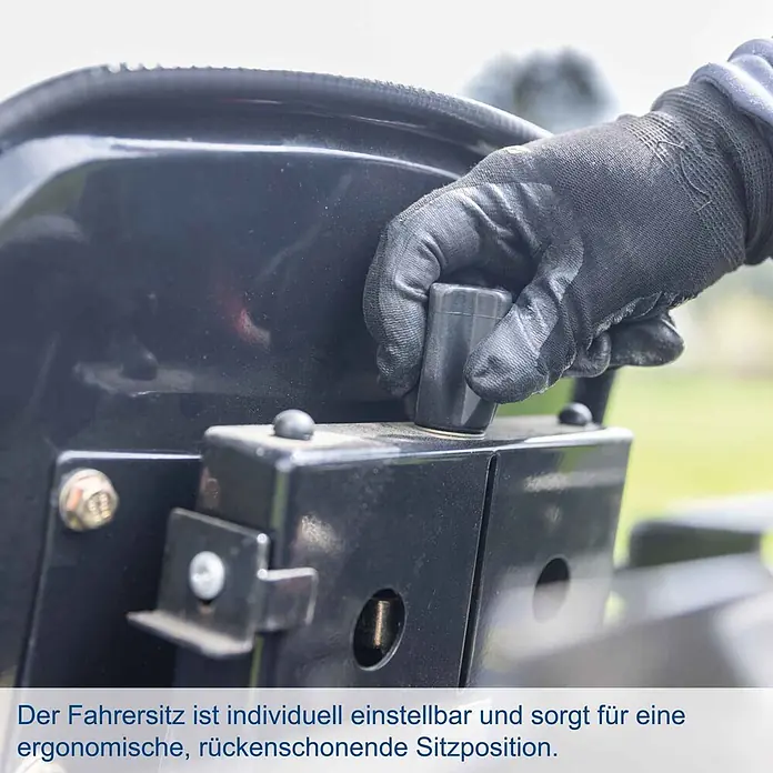 Scheppach Kleintraktor MT25 - Hubraum: 1.132 cm³, Tankvolumen: 10 l - Behandschuhte Hand verstellt schwarzen Einstellknopf am Fahrersitz für ergonomische Anpassung.