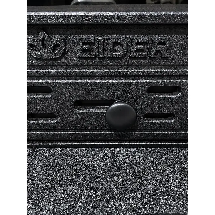 Insert Tracia - L x An x Al: 47 x 70 x 57 cm, 9,3 kW, 230 m³, Antracita - Componente EIDER gris oscuro con logo grabado y perilla de ajuste negra, sobre una alfombrilla gris texturizada.