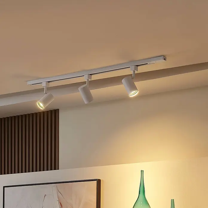 Prios LED-Spannseilsystem Jorell - weiß / opal, weiß / opal - Weiße Stromschiene mit drei zylindrischen Strahlern an der Decke, die den Raum mit warmem Licht erhellen.