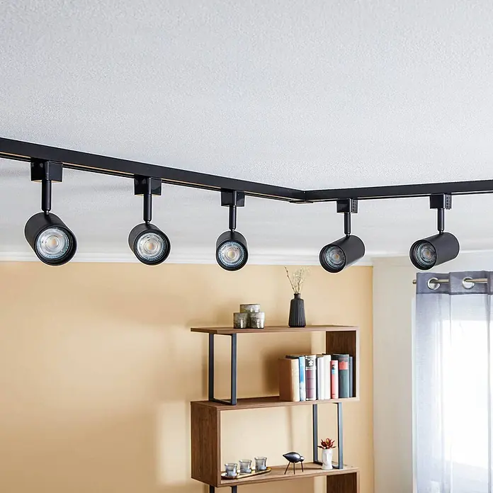 Prios LED-Spannseilsystem Jorell - schwarz, schwarz - Schwarze L-förmige Stromschienenbeleuchtung mit mehreren Strahlern an einer Decke montiert.