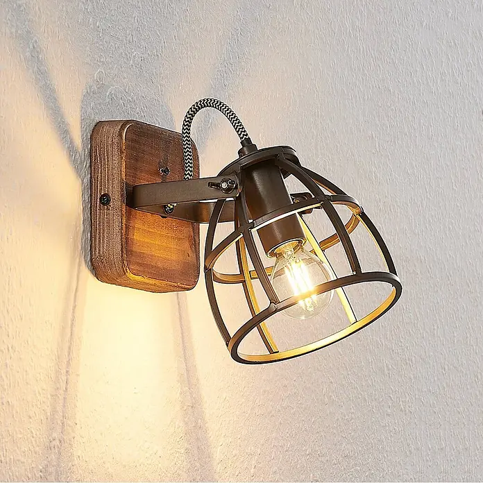 Lindby Wandleuchte innen in schwarz, braun, Wandstrahler -  - Wandleuchte im Industriestil mit Holzhalterung, dunklem Metallkäfigschirm, geflochtenem Kabel und beleuchteter Glühbirne.
