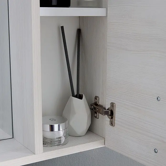 Kiamami Valentina LED-Spiegelschrank - B x H: 155 x 570 cm, Weiß - Offenes helles Holzregal mit einem Tiegel Creme und einer weißen geometrischen Diffusorvase mit schwarzen Stäbchen.