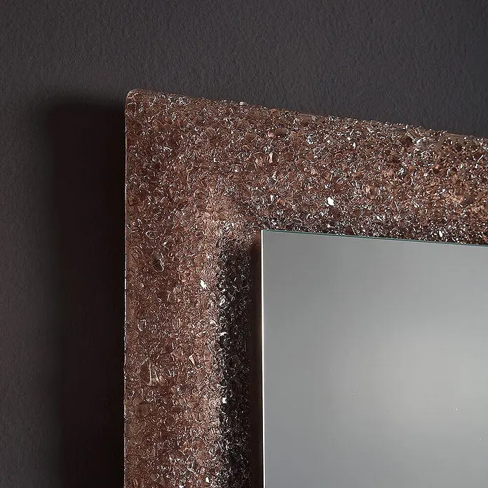 Kiamami Valentina Lichtspiegel - 0,02 x 620 cm, Farblos - Spiegel mit einem strukturierten, bräunlich-bronzenen Rahmen aus zerbrochenem Glas an einer dunklen Wand.