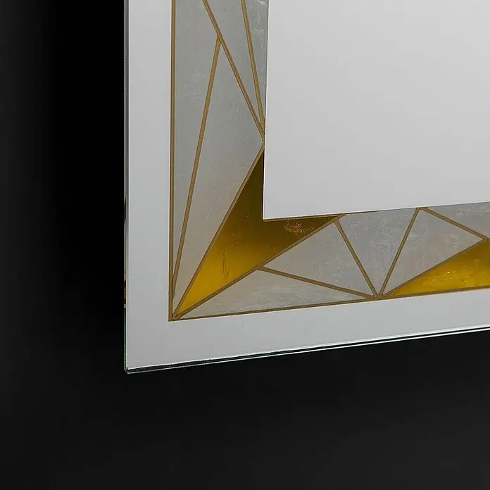 Kiamami Valentina Lichtspiegel - 20 x 800 cm, Farblos - Ecke eines Spiegels mit einem geometrischen Art-Déco-Muster in Gold und durchscheinendem Weiß.