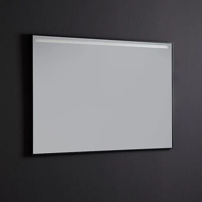 Kiamami Valentina Lichtspiegel - 20 x 700 cm, Chrom - Rechteckiger Spiegel mit schwarzem Rahmen und integrierter LED-Lichtleiste oben, an einer dunklen Wand montiert.