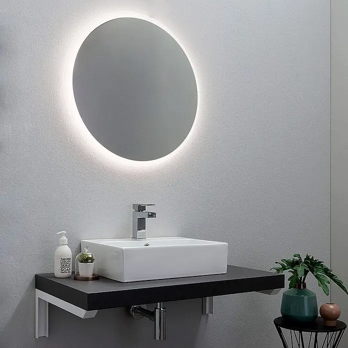 Kiamami Valentina Lichtspiegel - 25 x 700 cm, Farblos - Ein modernes Badezimmer mit einem runden LED-Spiegel über einem weißen Waschbecken auf einer schwarzen schwebenden Waschtischplatte.