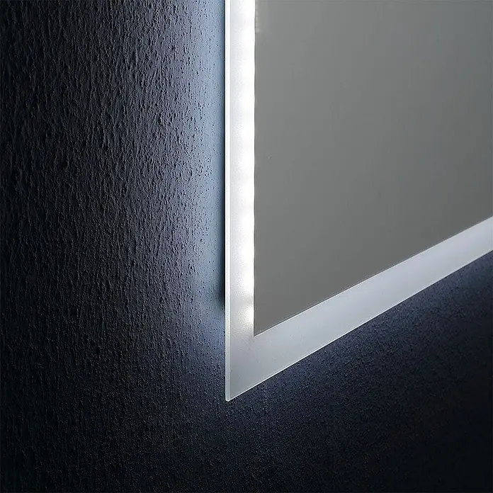 Kiamami Valentina Lichtspiegel - 25 x 600 cm, Farblos - Nahaufnahme eines modernen, beleuchteten Spiegels, der eine dunkle, texturierte Wand mit hellem LED-Licht erhellt.
