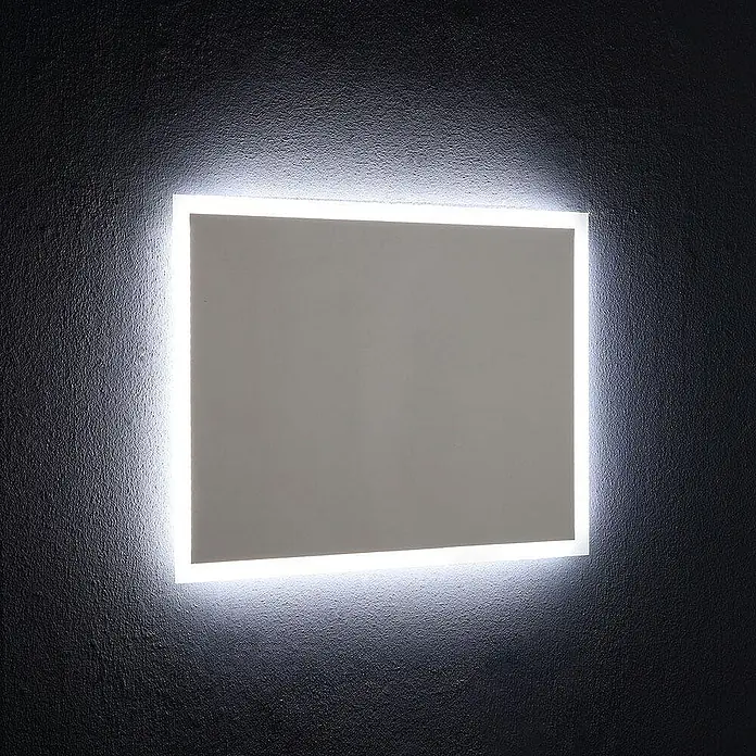 Kiamami Valentina Lichtspiegel - 25 x 600 cm, Farblos - Rechteckiger Spiegel mit heller weißer LED-Hintergrundbeleuchtung, an einer dunklen strukturierten Wand montiert.
