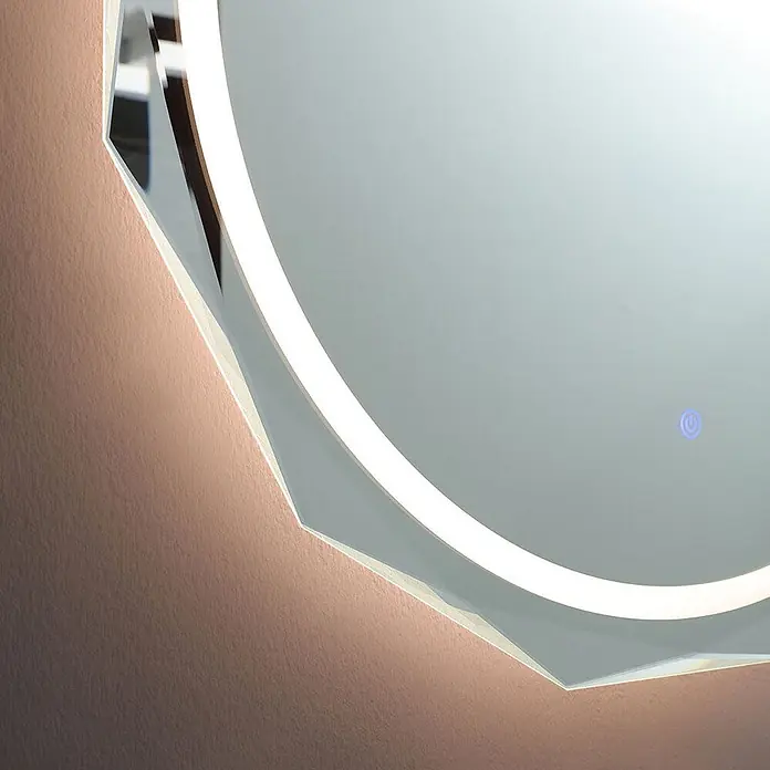 Kiamami Valentina Lichtspiegel - 0,02 x 760 cm, Farblos - Nahaufnahme eines hinterleuchteten LED-Spiegels mit facettierter Kante und sichtbarem Touch-Power-Symbol, der einen warmen Schein auf die Wand wirft.