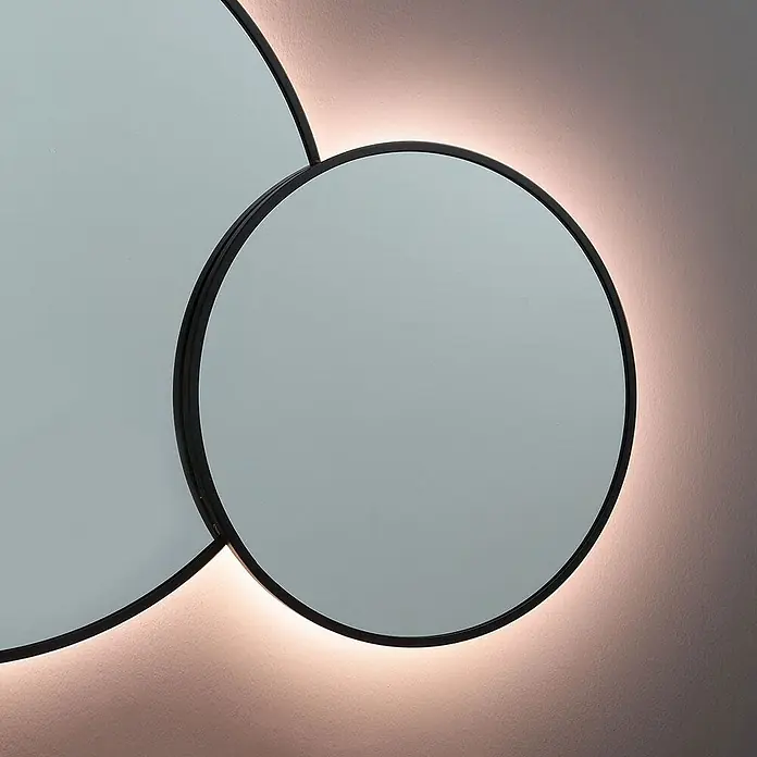 Kiamami Valentina Lichtspiegel - 0,02 x 700 cm, Schwarz - Zwei sich überlappende Rundspiegel mit schwarzen Rahmen und Hintergrundbeleuchtung, die ein sanftes Leuchten an der Wand erzeugt.