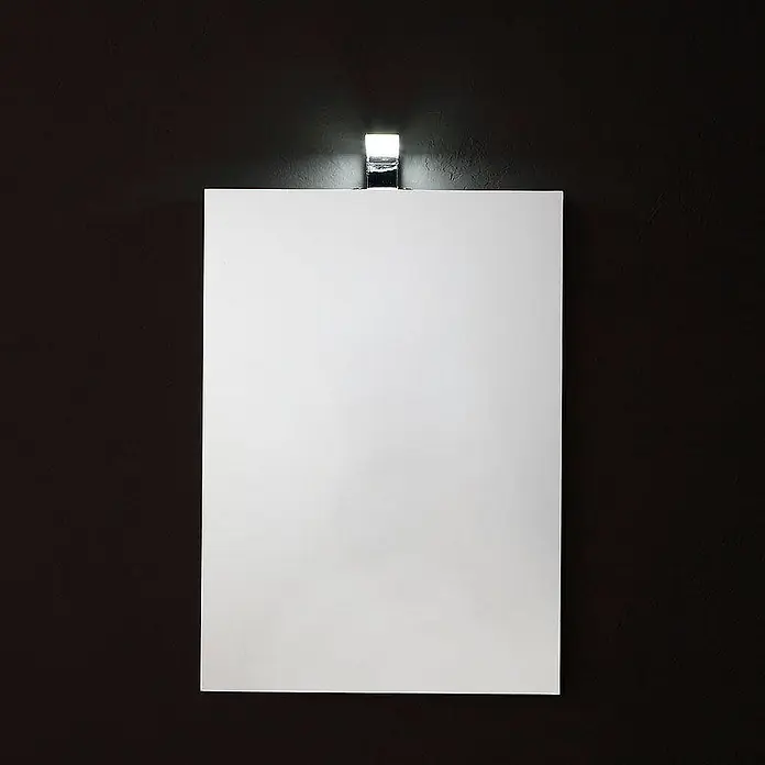 Kiamami Valentina Lichtspiegel - 20 x 700 cm, Farblos - Weißes rechteckiges Panel mit Chromleuchte darüber, an einer dunklen, strukturierten Wand befestigt.