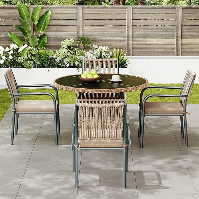 SONNENH Gartenmöbel-Set - 5 -tlg., Eisen, Polyester, Gehärtetes Glas, Grau - Gartensitzgruppe: Runder, dunkler Tisch mit Rattan-Details, vier Stühle mit dunkelgrauem Metallgestell, Rattanlehnen und beigen Kissen auf Terrasse.