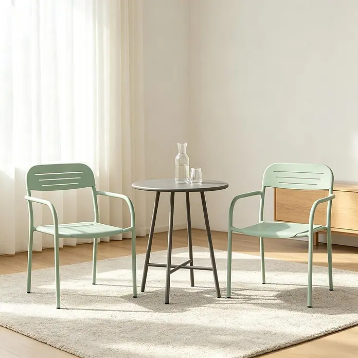 SONNENH Garten-Stapelstühle aus Metall, 2er-Set, Salbeigrün -  - Zwei mintgrüne Stühle mit Armlehnen und ein dunkelgrauer runder Tisch mit Glaskaraffe und Becher, auf hellem Teppich in Innenräumen.