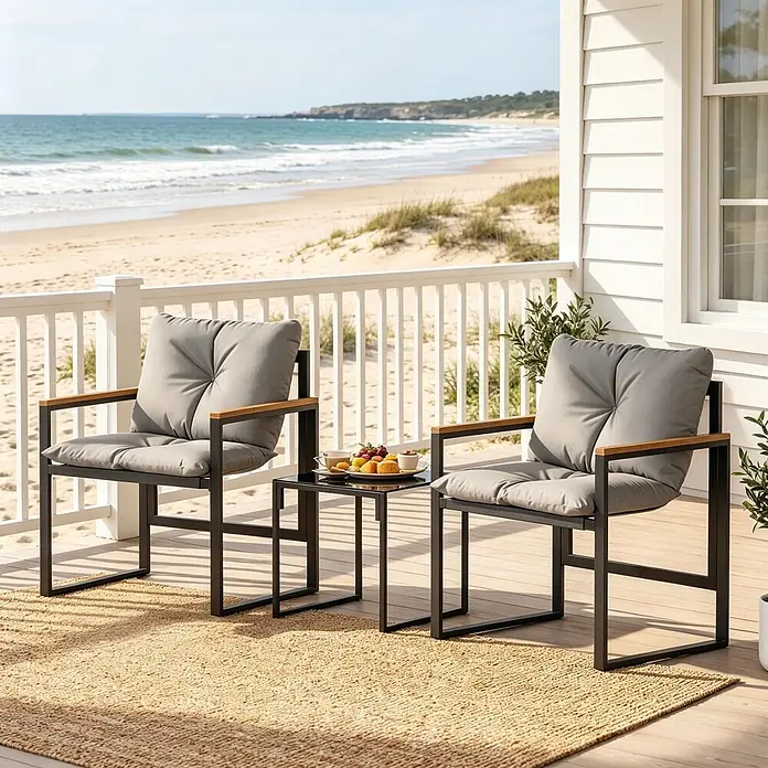 SONNENH Balkonmöbel-Set - 3 -tlg., Baumwolle, Metall, Polyester, Gehärtetes Glas, Textilene, Schwarz - Zwei schwarze Metall-Gartenstühle mit Holzarmlehnen und grauen Kissen, neben einem schwarzen Beistelltisch, auf einer Terrasse mit Strandblick.