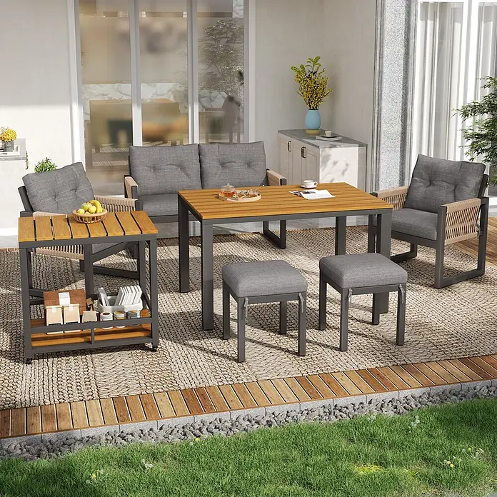 SONNENH Gartenmöbel-Set - 6 -tlg., Eisen, Polyester, Schaumstoff, Holz, Kunststoff, Grau/Natur - Eine Outdoor-Ess- und Lounge-Möbelgruppe mit grauen Kissen, Holzplatten und dunklen Metallrahmen auf einer Terrasse. Sie umfasst Tisch, Sofa, zwei Stühle, zwei Hocker und Beistelltisch.