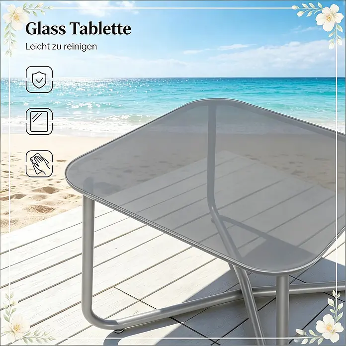 SONNENH Balkonmöbel-Set - 3 -tlg., Glas, Metall, Grau - Kleiner Glastisch mit grauer Platte und silbernem Metallgestell auf einer Terrasse am Meer.