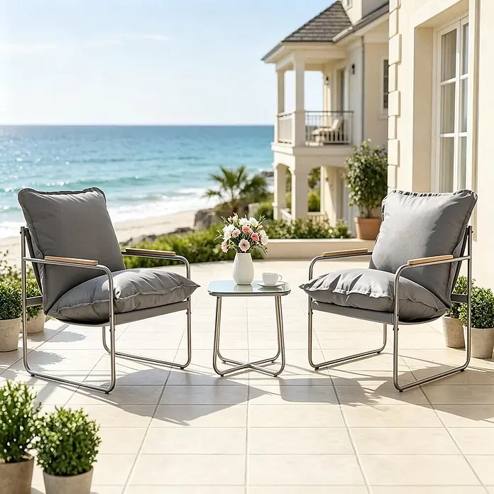 SONNENH Balkonmöbel-Set - 3 -tlg., Glas, Metall, Grau - Zwei graue Outdoor-Sessel mit Metallgestell und ein Glastisch auf einer sonnigen Terrasse mit Meerblick.