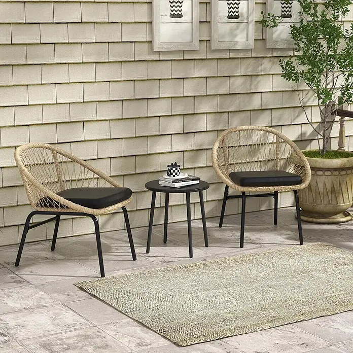 SONNENH Balkonmöbel-Set - 3 -tlg., Rattan, Gelb - Eine Outdoor-Terrassengarnitur mit zwei beigen Korbstühlen mit schwarzen Kissen und einem runden schwarzen Tisch auf einer gefliesten Terrasse mit Teppich.