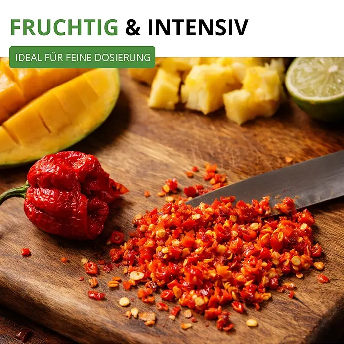 Deine Gartenwelt Chili Trinidad Moruga Scorpion -  - Fein gehackter und ganzer roter Chili, Mango, Ananas und Limette auf Brett. Betont fruchtig-intensiven Geschmack für feine Dosierung.