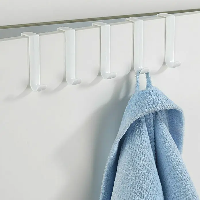 Wenko Türhaken - 5 Stk., Weiß - Nahaufnahme einer weißen Türgarderobe mit blauem Handtuch.