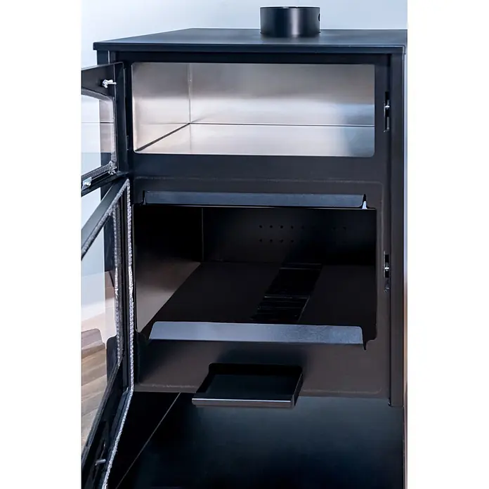 Estufa de leña Aston con horno - 10,2 kW - 13,1 kW, Volumen de calefacción: 225 m³, Negro - Interior de estufa metálica negra abierta con cámara superior brillante, múltiples compartimentos y bandeja de cenizas extraíble.