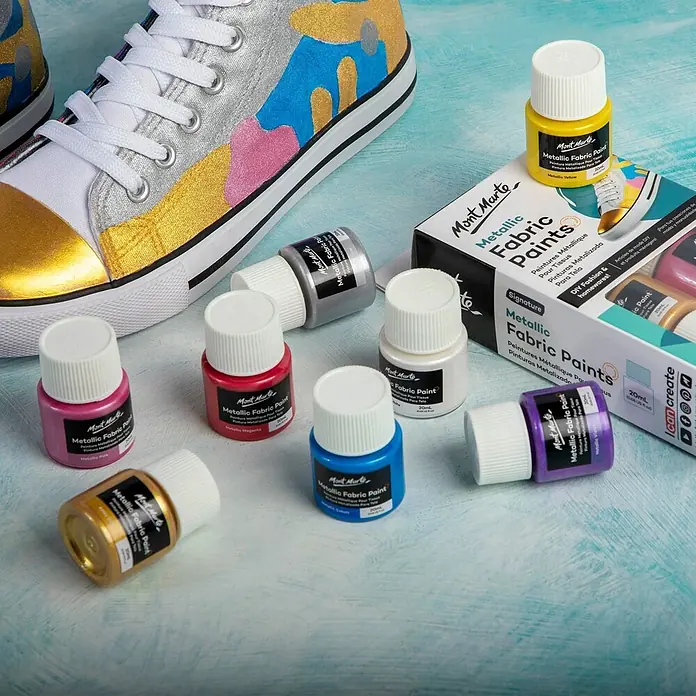 Mont Marte Textilmalfarben-Set Metallic Signature - 8x20ml - mehrfarbig, 8 Stk. x 20 ml - Mont Marte Metallic Stofffarben in verschiedenen Farben, gezeigt mit einem individuell bemalten Sneaker.