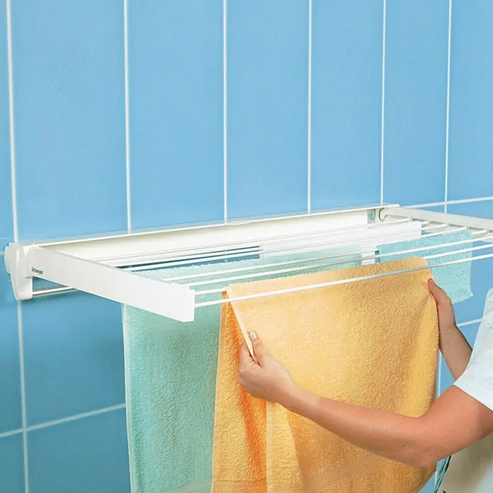 Juwel Wandwäschetrockner ARTDRY 70 - Länge Wäscheleine: 4 m, 75,5 cm, Farbe: Weiß - Wäscheständer an einer blau gefliesten Wand mit Handtüchern zum Trocknen, eine praktische Lösung für kleine Räume.