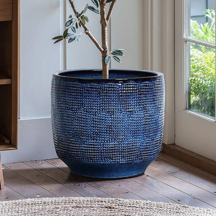 Hometopia Pflanztopf HTPL0036-L - 1 Stk., Außenmaß (Ø x H): 40 x 28,5 cm, Keramik, Marineblau - Großer, dunkelblauer Keramiktopf mit strukturierter Oberfläche, der einen kleinen Baum enthält. Er steht auf einem Holzfußboden.