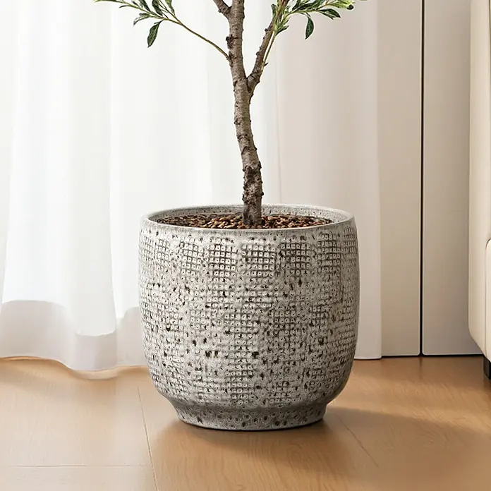 Hometopia Pflanztopf HTPL0327-M - 1 Stk., Außenmaß (Ø x H): 31 x 29 cm, Keramik, Graues - Ein großer, runder, strukturierter grauer Pflanzkübel mit Pflanze, auf hellem Holzboden neben weißen Vorhängen stehend.