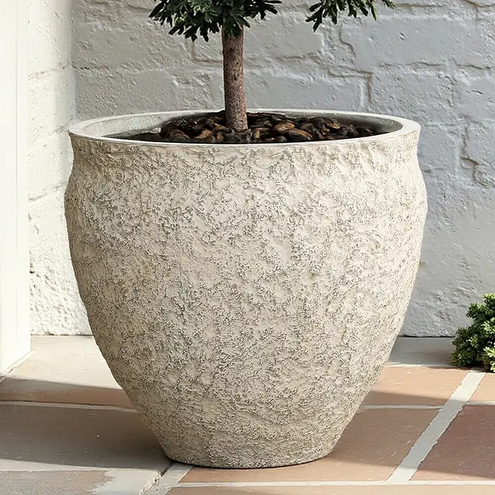 Blumentopf Groß, Rund Übertöpfe Betonoptik für Außen & Innen -  - Großer, strukturierter, hellbeiger Pflanztopf mit kleinem Baum auf einer Außenterrasse.