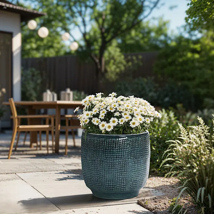Hometopia Pflanztopf HTPL0037-M - 1 Stk., Außenmaß (Ø x H): 31 x 29 cm, Keramik, Dunkelgrün - Großer dunkelpetrolfarbener, texturierter Pflanzkübel mit weißen Gänseblümchen auf einer Terrasse im Garten.