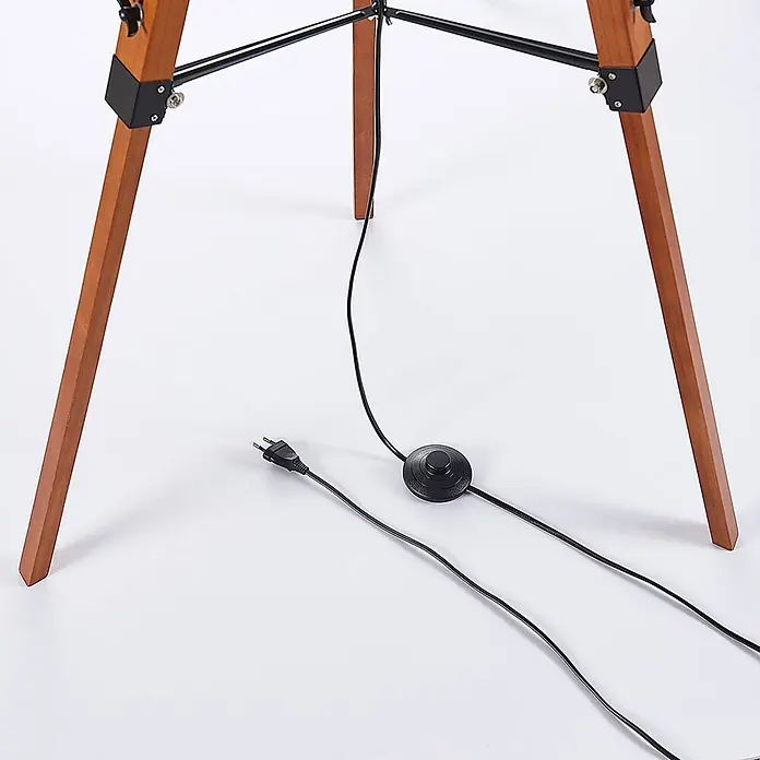 Lindby Stehlampe Wohnzimmer, Tripod in dunkelbraun, schwarz, Stehleuchte -  - Holzbeine einer Stehlampe mit schwarzem Metallrahmen, Stromkabel, Fußschalter und Stecker.