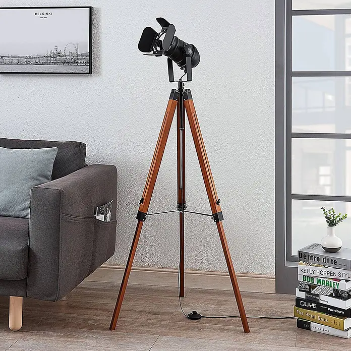 Lindby Stehlampe Wohnzimmer, Tripod in dunkelbraun, schwarz, Stehleuchte -  - Schwarze Stehleuchte im Scheinwerfer-Stil mit Holzstativ in modernem Wohnzimmer-Ambiente.