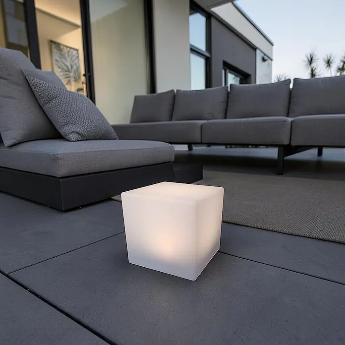 DAPO Solar-Dekoleuchte LED Solar-Leuchte Mate Würfel 30cm - L x B x H: 30 x 30 x 30 cm, Weiß, IP67 - Weißes, durchscheinendes Würfellicht beleuchtet eine Terrasse neben grauen Loungemöbeln.